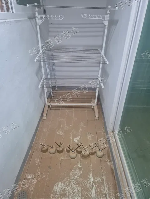 다용도실 건조대 아래 토사로 뒤덮인 바닥