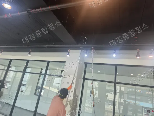 기둥의 벗겨진 부분을 손보는 주황 상의 작업자