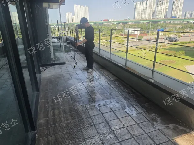 발포세제로 발코니 타일 바닥을 고압세척하는 모습