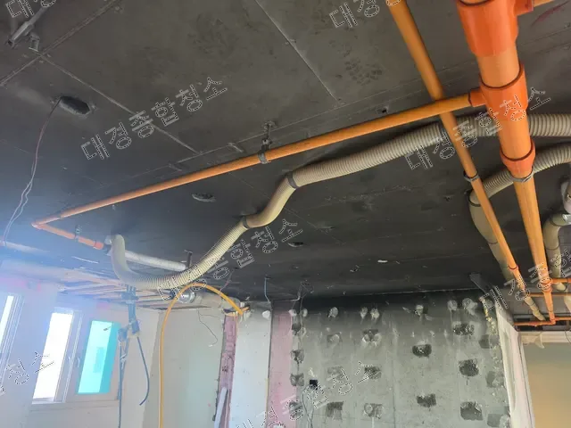 화재로 그을린 천장과 노출된 오렌지색 배관
